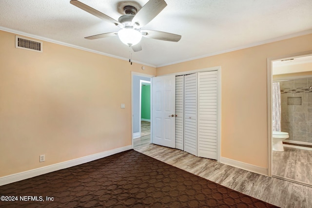 unfurnished bedroom featuring visible vents, crown molding, and wood finished floors