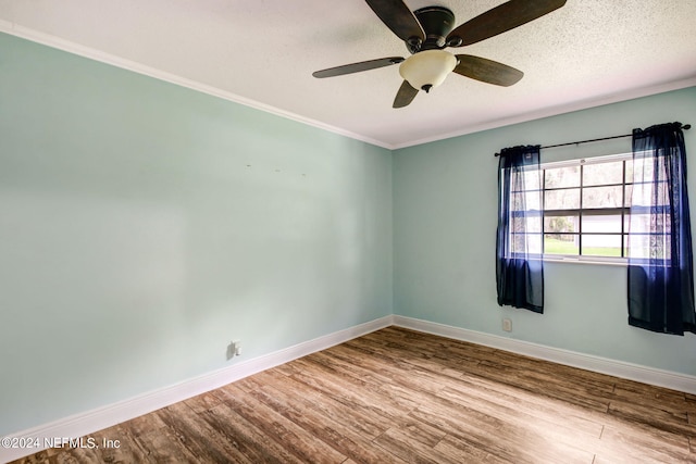 unfurnished room featuring ornamental molding, ceiling fan, a textured ceiling, wood finished floors, and baseboards