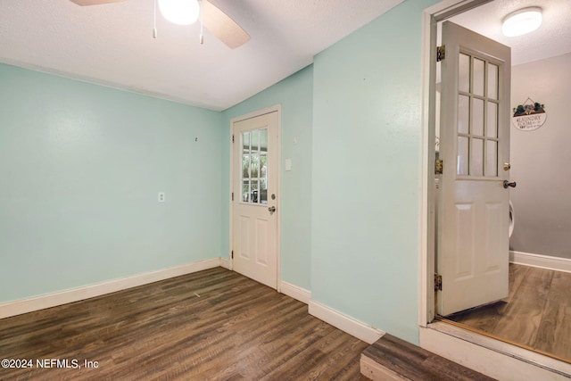 foyer entrance featuring a ceiling fan, a textured ceiling, baseboards, and wood finished floors