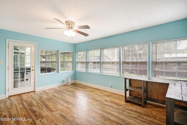 unfurnished sunroom featuring ceiling fan