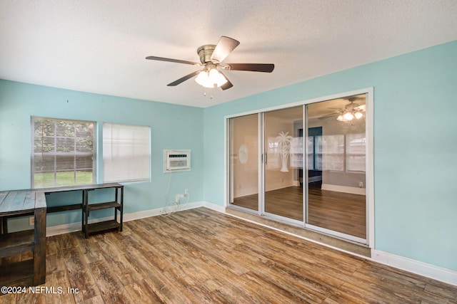 spare room featuring a textured ceiling, baseboards, and wood finished floors