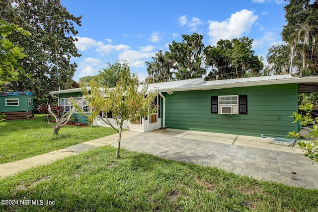 exterior space with metal roof, a patio, and a yard