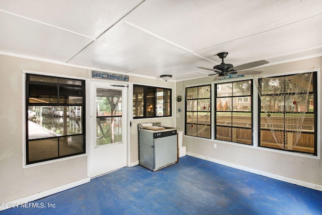 unfurnished sunroom featuring a ceiling fan