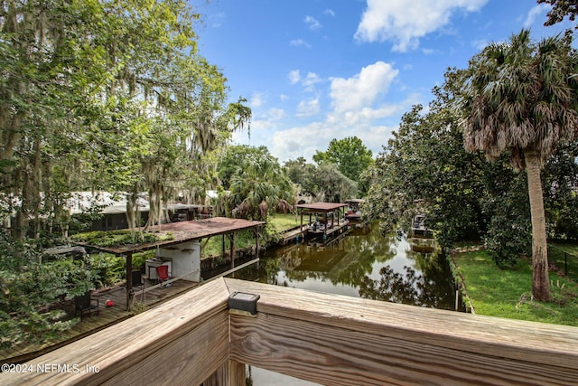 dock area featuring a lawn and a water view