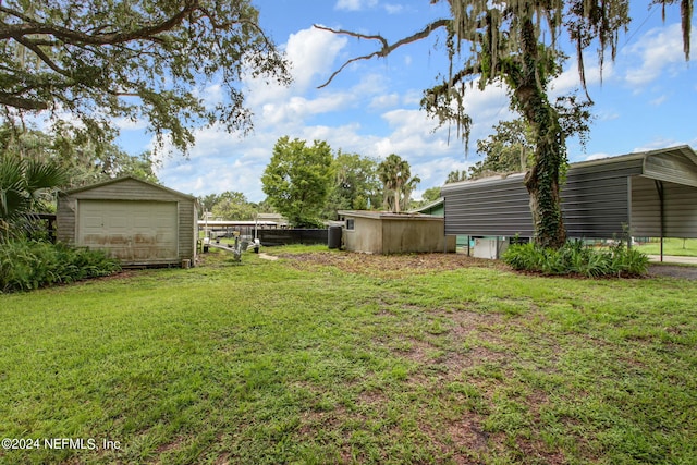 view of yard featuring an outbuilding, a detached garage, and driveway