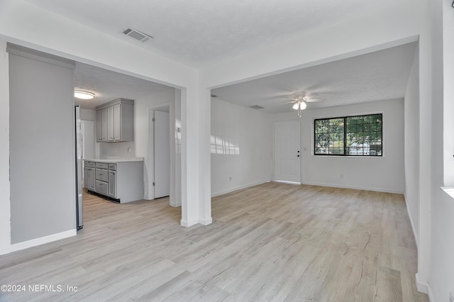 4435 Bedivere Rd, Jacksonville, FL 32208 - unfurnished living room featuring light wood finished floors, a textured ceiling, visible vents, and a ceiling fan