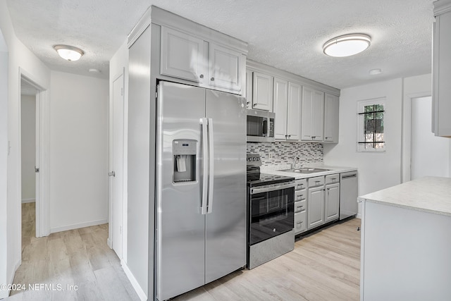 4435 Bedivere Rd, Jacksonville, FL 32208 - kitchen featuring a sink, gray cabinets, light wood-style flooring, and appliances with stainless steel finishes