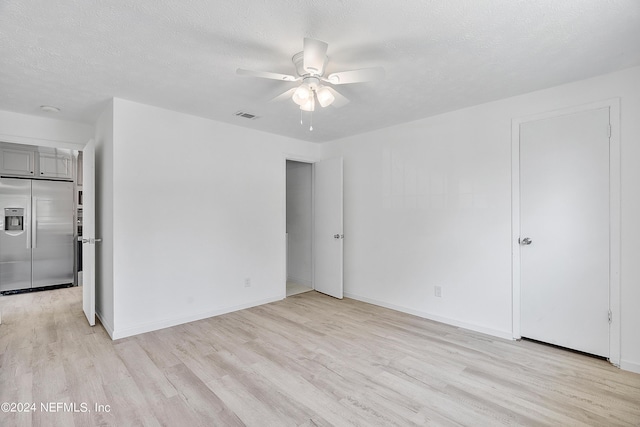 4435 Bedivere Rd, Jacksonville, FL 32208 - unfurnished bedroom featuring light wood-style flooring, stainless steel built in refrigerator, a textured ceiling, and visible vents
