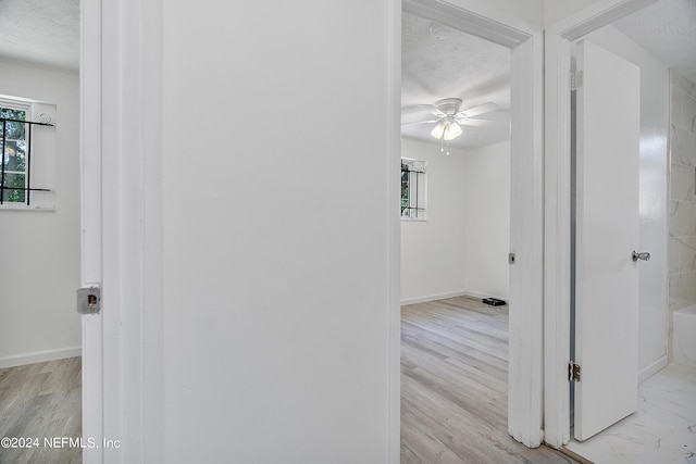4435 Bedivere Rd, Jacksonville, FL 32208 - corridor featuring baseboards, a textured ceiling, and wood finished floors