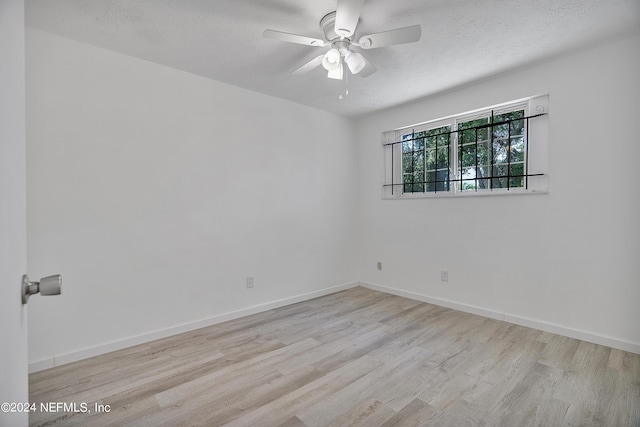 4435 Bedivere Rd, Jacksonville, FL 32208 - spare room featuring a textured ceiling, baseboards, ceiling fan, and wood finished floors