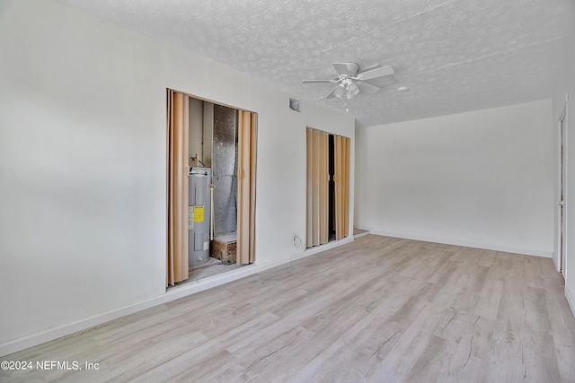4435 Bedivere Rd, Jacksonville, FL 32208 - empty room with a textured ceiling, baseboards, ceiling fan, water heater, and light wood-style floors