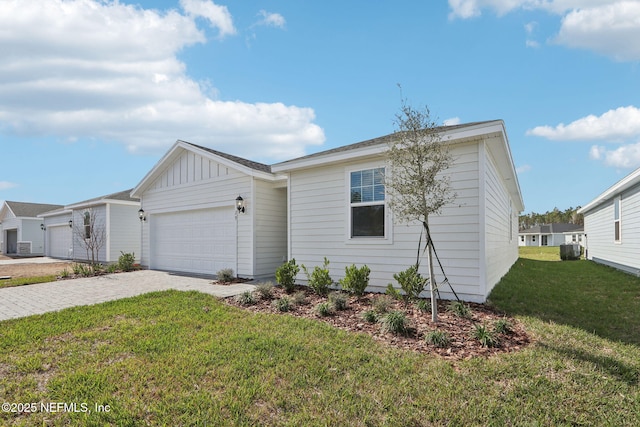 single story home featuring a garage, decorative driveway, board and batten siding, and a front yard