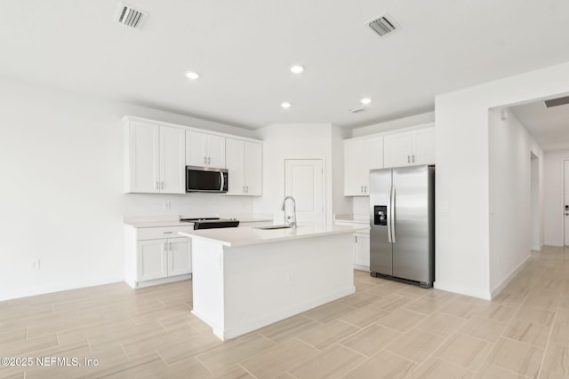 kitchen with visible vents, stainless steel appliances, a sink, and light countertops