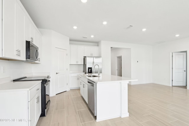 kitchen featuring light countertops, appliances with stainless steel finishes, a sink, and white cabinetry