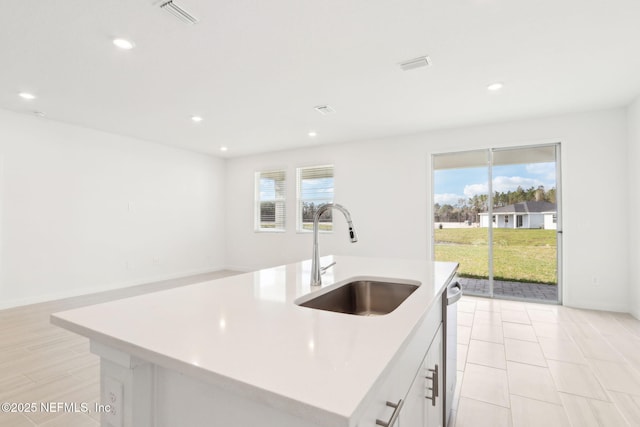 kitchen with light countertops, plenty of natural light, visible vents, and a sink