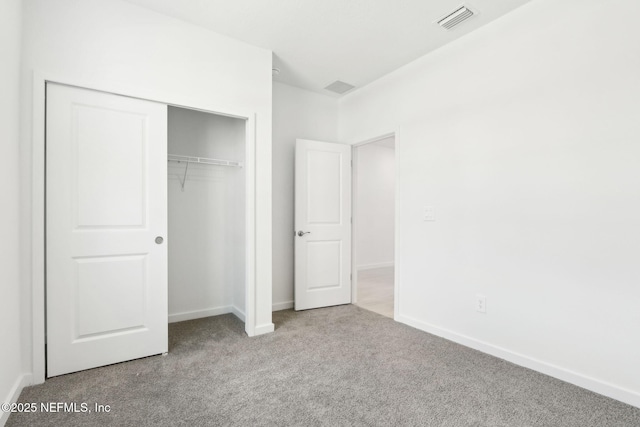 unfurnished bedroom featuring carpet floors, a closet, visible vents, and baseboards