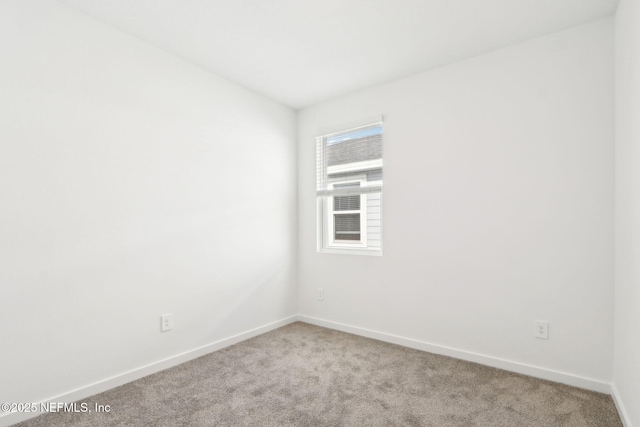 carpeted spare room with baseboards