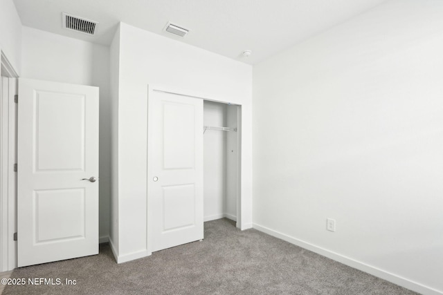 unfurnished bedroom featuring a closet, visible vents, baseboards, and carpet flooring