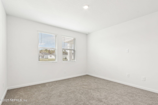 carpeted spare room with baseboards