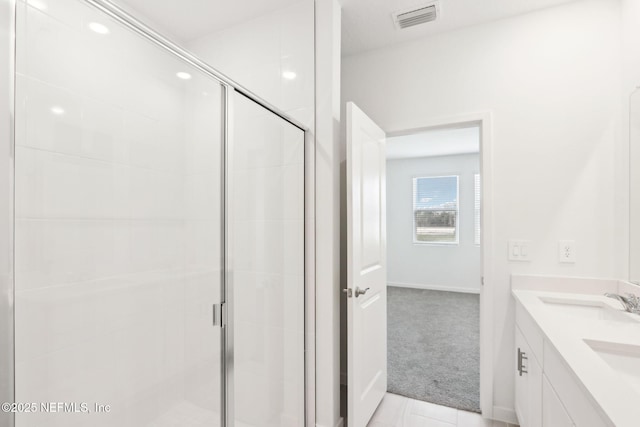 bathroom with double vanity, a stall shower, a sink, and visible vents