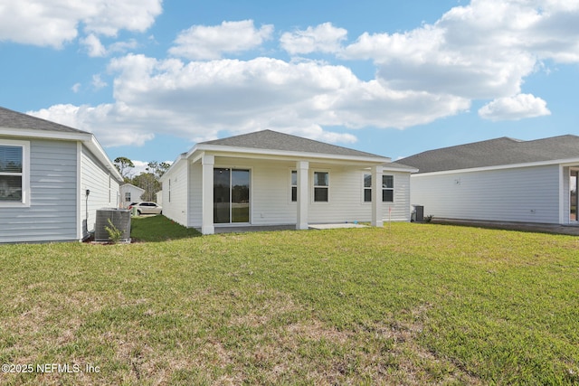 rear view of house with a lawn and cooling unit