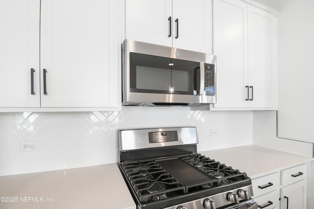 kitchen featuring white cabinetry, decorative backsplash, and stainless steel appliances