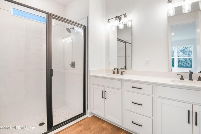 bathroom with a shower with door, vanity, and hardwood / wood-style floors