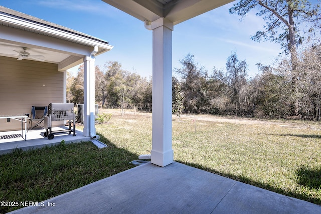 view of yard featuring ceiling fan and a patio