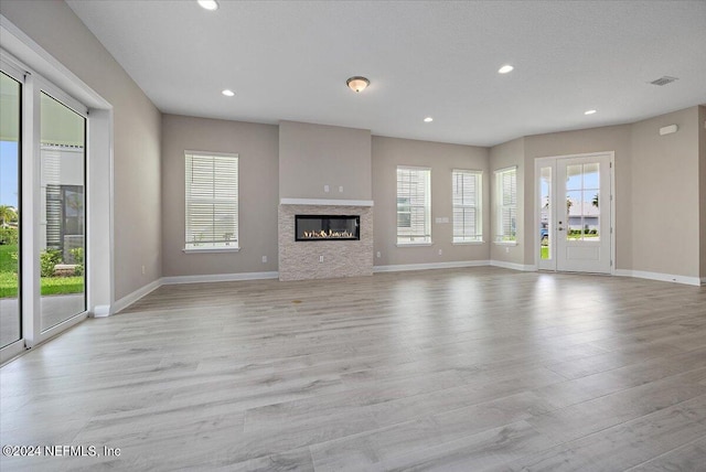 unfurnished living room featuring light hardwood / wood-style flooring and plenty of natural light