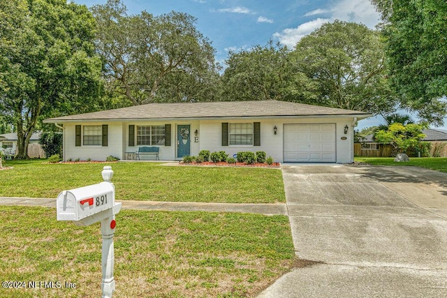 single story home with a garage and a front lawn