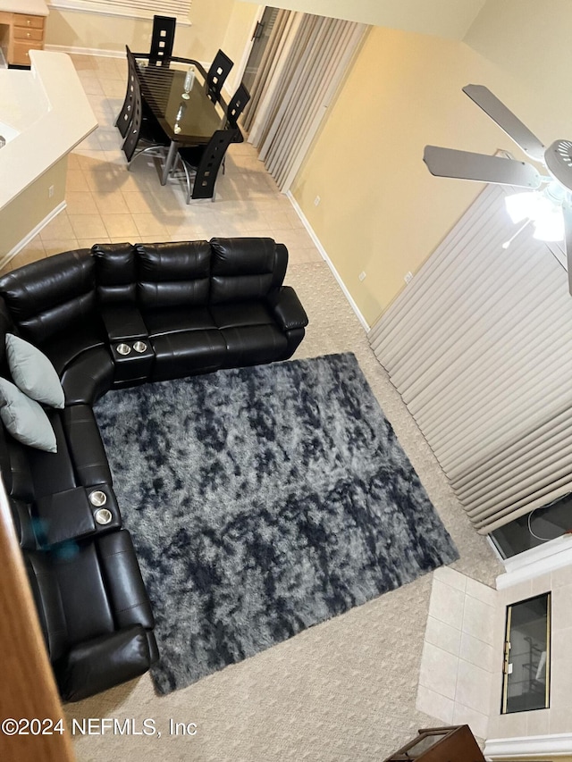 carpeted living room featuring ceiling fan and baseboards