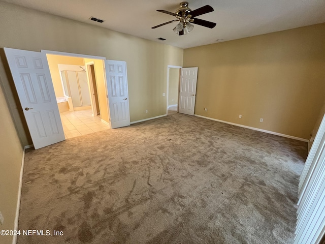 unfurnished bedroom featuring carpet floors, tile patterned flooring, visible vents, and baseboards