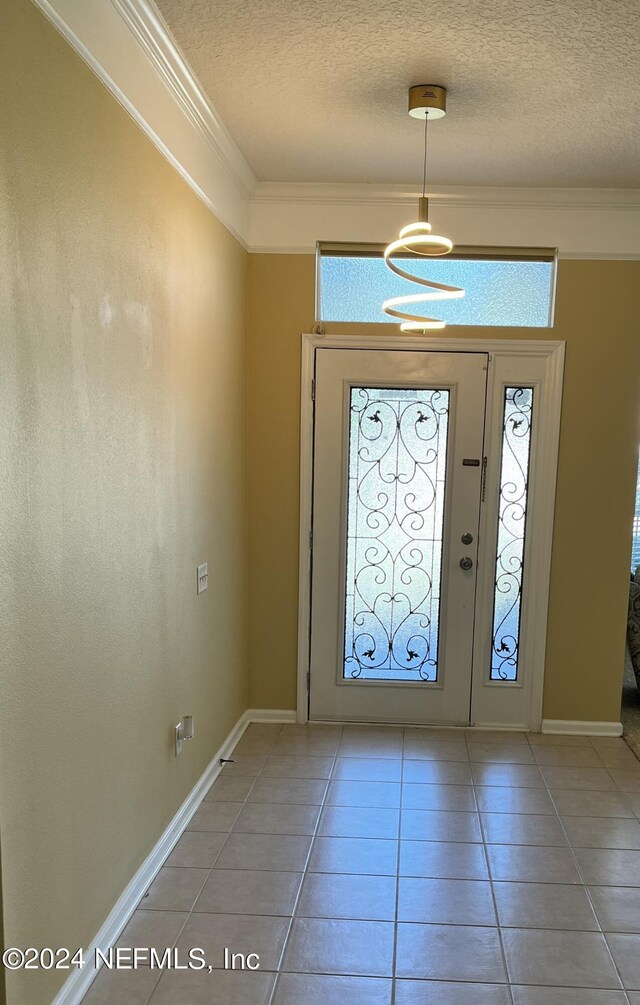 foyer entrance featuring a healthy amount of sunlight, tile patterned floors, and a textured ceiling