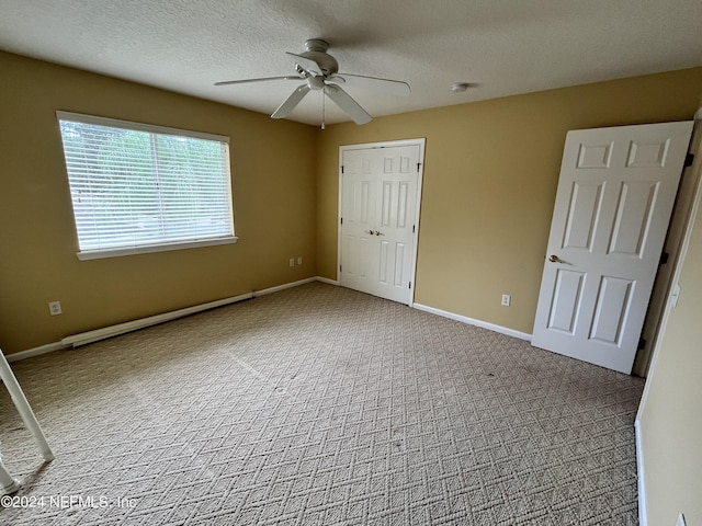 unfurnished bedroom featuring baseboards, ceiling fan, a textured ceiling, carpet flooring, and a closet