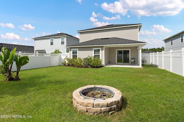 rear view of property featuring a patio area and a lawn