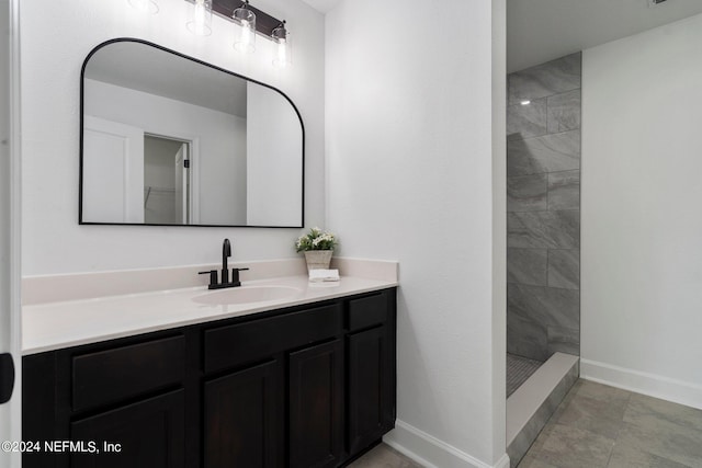 bathroom with tiled shower, tile patterned floors, and vanity