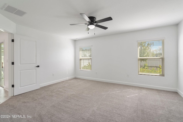 carpeted spare room with ceiling fan and a healthy amount of sunlight