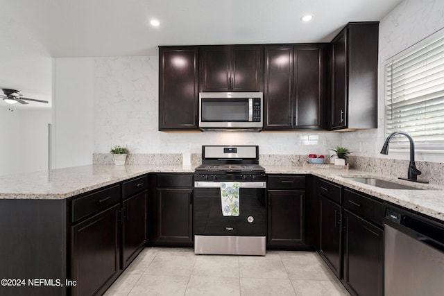 kitchen with stainless steel appliances, sink, light tile patterned floors, kitchen peninsula, and ceiling fan