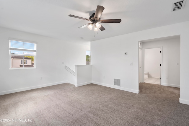 carpeted empty room with ceiling fan and a healthy amount of sunlight