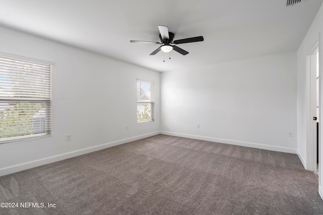 empty room featuring ceiling fan and carpet