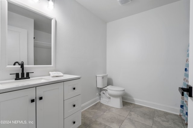 bathroom featuring tile patterned flooring, toilet, and vanity