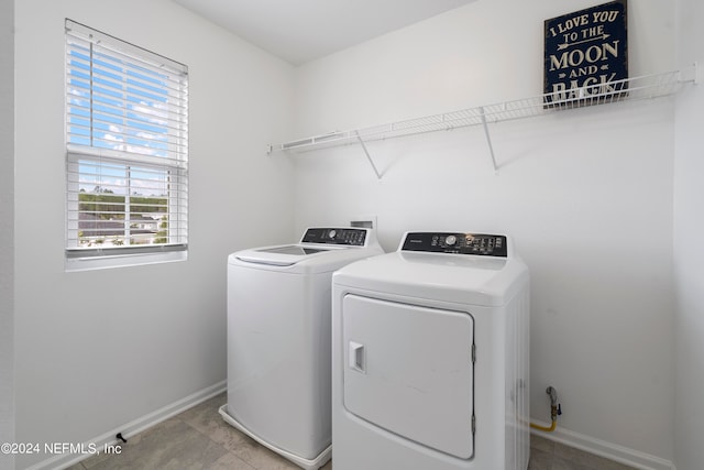 washroom with independent washer and dryer and light tile patterned floors