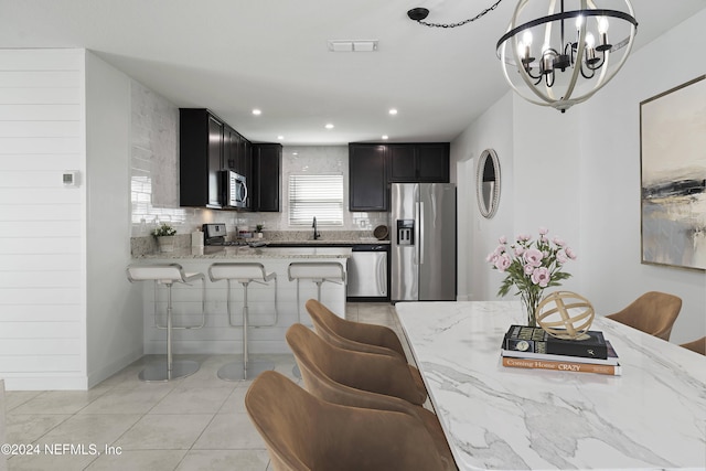 kitchen featuring backsplash, appliances with stainless steel finishes, and light stone counters