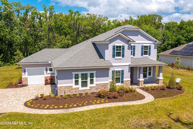 view of front property featuring a garage, a porch, and a front lawn