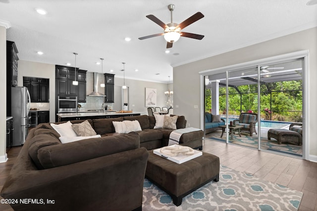 living room with crown molding, sink, ceiling fan, and light hardwood / wood-style floors