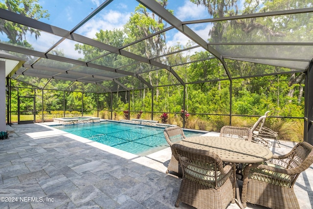 view of swimming pool with an in ground hot tub, a lanai, and a patio area