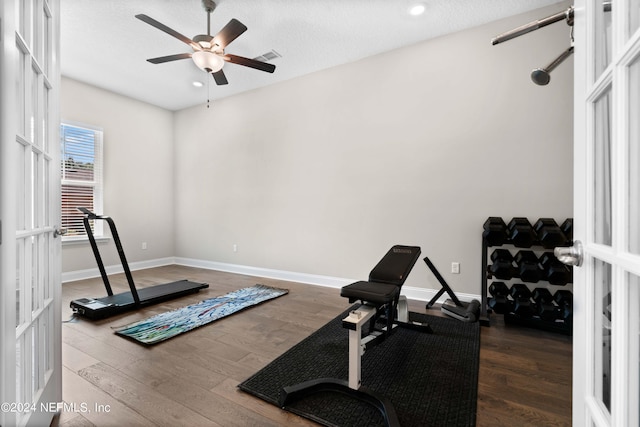 workout area featuring ceiling fan, hardwood / wood-style floors, and a textured ceiling