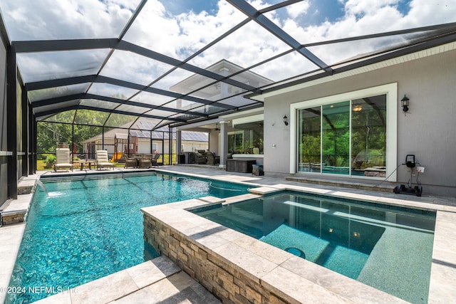 view of swimming pool featuring an in ground hot tub, pool water feature, a patio area, and glass enclosure