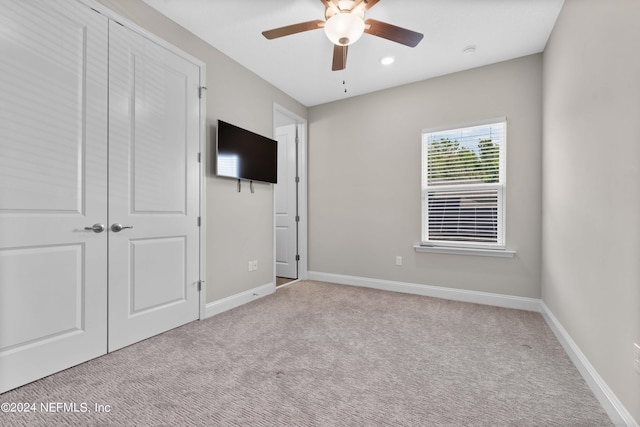 unfurnished bedroom featuring light colored carpet and ceiling fan