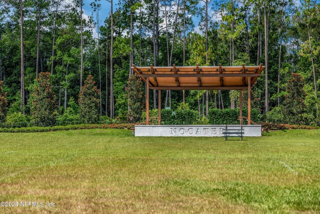 view of property's community with a pergola and a lawn